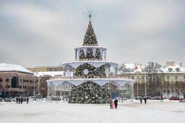 Vilnius, Litvanya - 20 Aralık 2022: Karlı büyük bir pastanın içindeki güzel Noel ağacı, kentin 700. yıldönümünü kutlayan halk ve turistler, Vilnius Katedrali, Litvanya, Avrupa