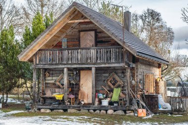 Beautiful old traditional wooden house with clay pots on the fence in the village of Margionys, Dzkija or Dainava region, Lithuania, in winter or spring