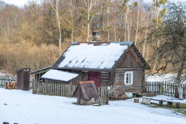 Beautiful old traditional wooden house with clay pots on the fence in the village of Margionys, Dzkija or Dainava region, Lithuania, in winter or spring