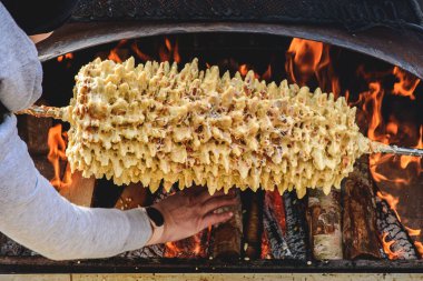 Litvanya ağaç pastası, akotis veya baumkuchenas, Polonya skacz, Belarus bankucha, tereyağı, yumurta beyazı ve sarısından yapılmış Alman baumkuchen, un, şeker ve krema, açık ateşte pişirilmiş.