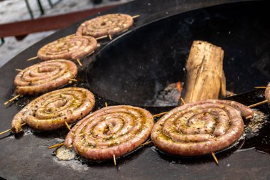 Sosisler yemeye, ızgara yapmaya ya da ateşte kızartılmaya hazır sokak yemekleri pazarında ya da açık hava pikniğinde yakın.