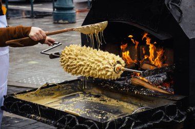 Litvanya ağaç pastası, akotis veya baumkuchenas, Polonya skacz, Belarus bankucha, tereyağı, yumurta beyazı ve sarısından yapılmış Alman baumkuchen, un, şeker ve krema, açık ateşte pişirilmiş.