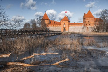Ortaçağ Trakai, Vilnius, Litvanya, Doğu Avrupa şatosu, güzel göller ve doğa arasında baharın başlarında tahta köprüyle donmuş göl arasında yer alıyor.