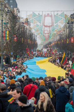 Vilnius Litvanya - 11 Mart 2023: Vilnius caddesi boyunca Litvanya ve Ukrayna bayraklarının taşıdığı dev Ukrayna bayrağı