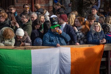 Vilnius, Litvanya - 18 Mart 2023: İrlanda Aziz Patrick Günü kutlamalarında bira içen büyük şapkalı çocuk Uzupis, Vilnius, Litvanya