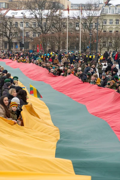 stock image Vilnius  Lithuania - March 11 2023: Huge Lithuanian flag along Gedimino avenue in Vilnius, carried by people with Lithuanian and Ukrainian flags, vertical