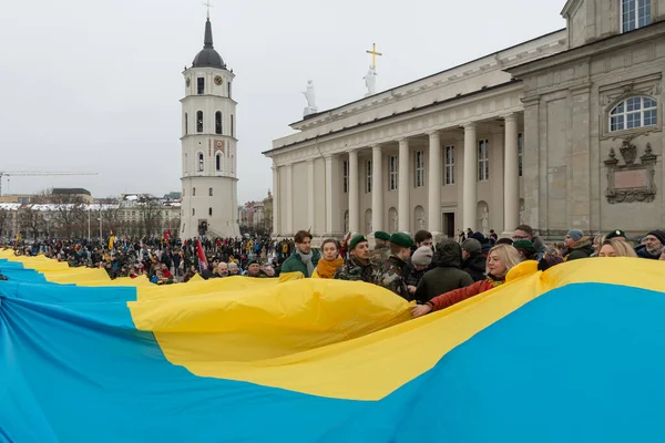维尔纽斯立陶宛 2023年3月11日 在维尔纽斯街道上悬挂着巨大的乌克兰国旗 由悬挂立陶宛和乌克兰国旗的人们举着 — 图库照片#