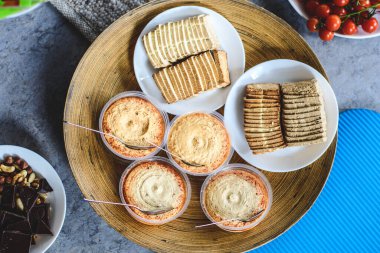 Vejetaryen yemeği, tofu, humus bir tabak çikolatayla birlikte bambu tepsisinde servis edilir, ve etrafında kurutulmuş meyve ve bir tabak vişneli domates.