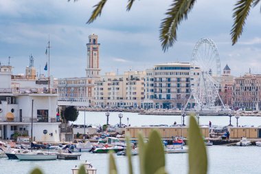 Bari, İtalya - 5 Nisan 2023: Bari, Puglia veya Apulia Panoraması, Güney İtalya Akdeniz, tekneler, sokak lambaları, dönme dolap ve deniz kenarında faşist mimari
