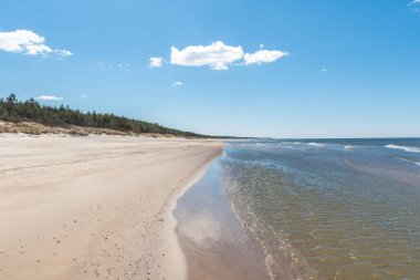 Baltık Denizi 'nde yürüyorum Palanga, Klaipeda, Litvanya' da, dalgalar, bulutlu gökyüzü, beyaz kumlu plaj ve sazlı kum tepeleri ve çam ağacı ormanlarıyla