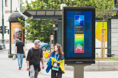 Vilnius, Litvanya - 22 Haziran 2023: Ukrayna bayrağı taşıyarak Litvanya 'nın başkenti Vilnius' ta yapılacak 2023 Nato zirvesi hakkında bilgilendirme pankartı
