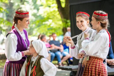 Riga, Letonya - 10 Temmuz 2023: Uluslararası Letonya Şarkı ve XVII Dans Festivali 'nde verilen aralarda geleneksel kıyafetli güzel kızlar