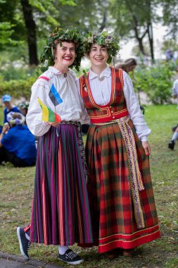 Vilnius, Litvanya - 7 Temmuz 2024: Ülke çapındaki Litvanya Şarkı ve Dans Festivali sırasında başında çiçek taç takmış birkaç kız 