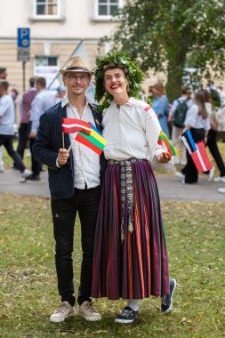 Vilnius, Litvanya - 7 Temmuz 2024: Ülke çapında Litvanya Şarkı ve Dans Festivali sırasında başında çiçek taç takan geleneksel giysili bir çift 