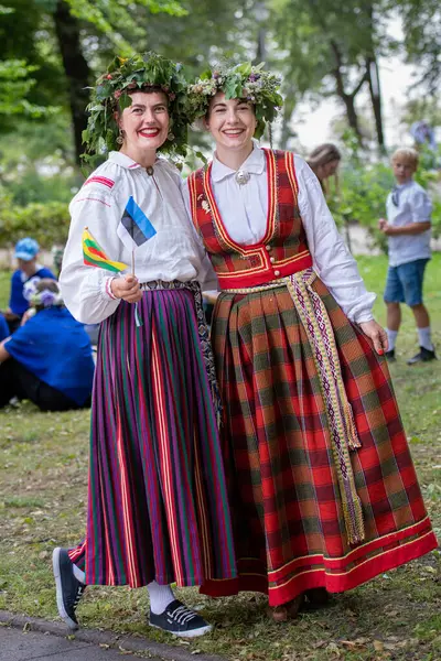 Vilnius, Litvanya - 7 Temmuz 2024: Ülke çapındaki Litvanya Şarkı ve Dans Festivali sırasında başında çiçek taç takmış birkaç kız 