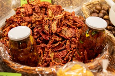 Taze biyo kırmızı olgun domatesler hasır sepette cam bir kavanozla sokak yiyecek pazarında, yakın çekim