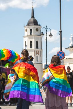 Vilnius, Litvanya - 7 Haziran 2025: Kamyonda gökkuşağı renkli balonlar ve LGBT + gururlu Vilnius geçit töreninde arka planda kule çanı ve katedrali olan birkaç kız,