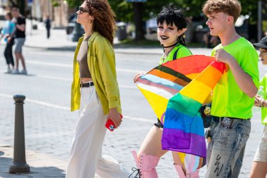 Vilnius, Litvanya - 7 Haziran 2025: Gökkuşağı renkli bayrağı olan sevimli genç kız, LGBT + Onur Yürüyüşü sırasında bir elf gibi yapılmış