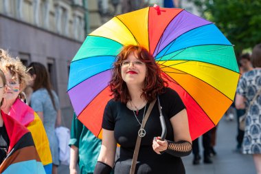 Vilnius, Litvanya - 7 Haziran 2025: LGBT + Onur Yürüyüşü sırasında gökkuşağı renkli şemsiyeli mutlu güzel kız