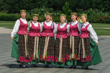 Vilnius, Litvanya - 14 Haziran 2025: Geleneksel Litvanya kıyafetleri ve kafalarında çiçek çelengi olan bir grup kız