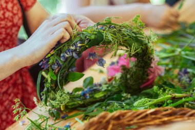 Bitkiler, yapraklar ve çiçeklerle yaz ortasında çelenk yapmak