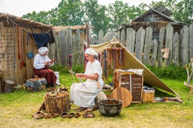 Kernave, Litvanya - 6 Temmuz 2025: Ortaçağ festivalinde bir kadın, Orta Çağ 'da kullanılan eski bir tekniği kullanarak deri ayakkabı yapıyor