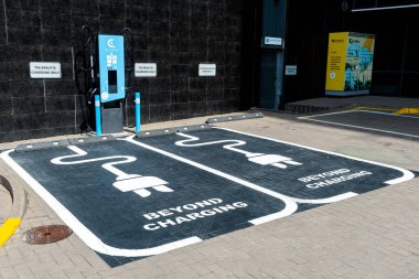 Vilnius, Litvanya - 27 Temmuz 2025: Belirlenmiş park alanındaki elektrik yükleme istasyonları ve park noktaları açık işaret ve tabela, yeşil enerji ve ulaşım kavramı 