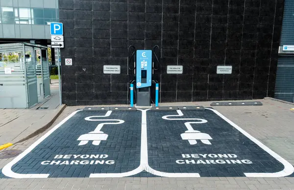 Vilnius, Litvanya - 27 Temmuz 2025: Belirlenmiş park alanındaki elektrik yükleme istasyonları ve park noktaları açık işaret ve tabela, yeşil enerji ve ulaşım kavramı 