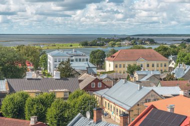 Haapsalu, Estonya 'nın ön planda çeşitli binaların çatılarının olduğu hava manzarası. Manzara Baltık Denizi 'ndeki adalara kadar uzanıyor.