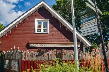 Haapsalu, Estonya - 17 Ağustos 2025: Haapsalu, Estonya, Avrupa 'da pitoresk bir alanda dekoratif çitleri olan büyüleyici kırmızı ahşap ev 