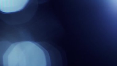 Soyut koyu mavi bokeh döngü arkaplan efekti. Yumuşak tonlu, titreşimli, odaklanmış dekor şablonu kopyalanmış uzay arka plakası. Makro yakın çekim ışıltı efekti ürün gösterimi arkaplan canlandırması.