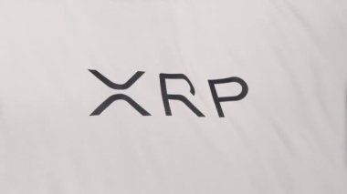 Beyaz bayrak arkaplanında XRP dalgalı sikke simgesi logosu. DeFi borsasında işlem güvence altına almak için blockchain teknolojisi kullanan şifreleme ve fintech için 3D animasyon.