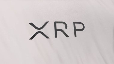 Beyaz bayrak arkaplanında XRP dalgalı sikke simgesi logosu. DeFi borsasında işlemleri güvence altına almak için engelleme teknolojisi kullanan şifreleme ve fintech için 3D illüstrasyon kavramı.