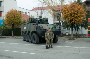 TARGU JIU, ROMANIA, CEMANIA 01.2022 Romanya Ulusal Günü Trgu jiu 'da zırhlı araçlar ve askeri kamyonların yanı sıra gala üniformalarında donatılmış Romen kara kuvvetleri askerleriyle geçit töreni