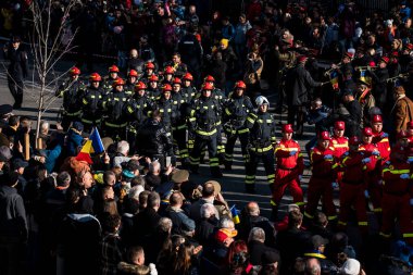 Targu-jiu 'daki ulusal geçit töreni. Üniformalı itfaiyeciler, koruyucu giysiler ve özel kırmızı itfaiye araçlarıyla.