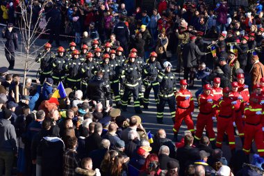 Targu-jiu 'daki ulusal geçit töreni. Üniformalı itfaiyeciler, koruyucu giysiler ve özel kırmızı itfaiye araçlarıyla.