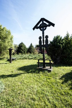 The roadside cross is carved in wood, with motifs dominated by the Orthodox cross and solar rosettes, it is located at forks and intersections of roads to ward off evil spirits
