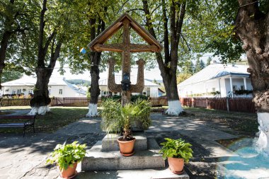 The roadside cross is carved in wood, with motifs dominated by the Orthodox cross and solar rosettes, it is located at forks and intersections of roads to ward off evil spirits