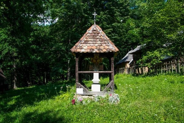 The roadside cross is carved in wood, with motifs dominated by the Orthodox cross and solar rosettes, it is located at forks and intersections of roads to ward off evil spirits