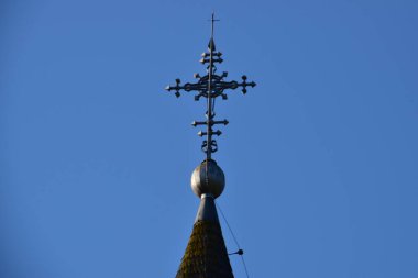Metal Orthodox cross on church tower towards blue sky, signifies connection between heaven and earth, upward aspiration, righteousness of life illuminated by faith