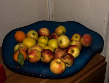 Fruits on a blue plate in the kitchen, closeup of photo