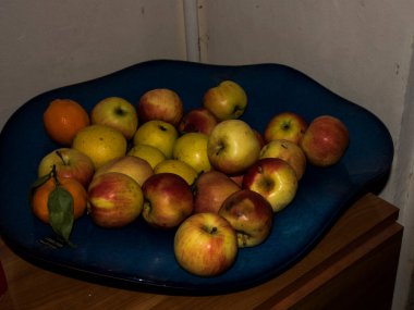 Fruits on a blue plate in the kitchen, closeup of photo