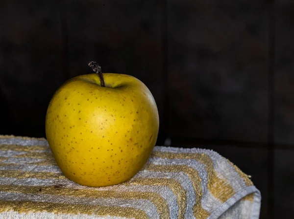 Yellow apple on a yellow background. Selective focus. Shallow depth of field