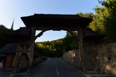 Maramures Gate, meşe ağacından yapılmış, genellikle farklı çiçek motifleriyle oyulmuş en az üç sütun, üst kapı eşiği kiremitlerle kaplı.