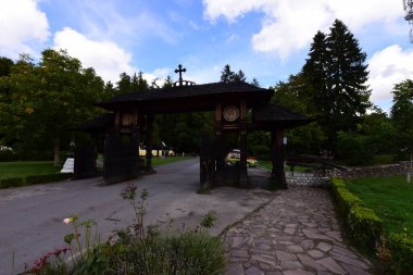 Maramures Gate, meşe ağacından yapılmış, genellikle farklı çiçek motifleriyle oyulmuş en az üç sütun, üst kapı eşiği kiremitlerle kaplı.