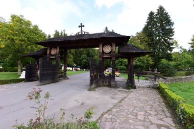 Maramures Gate, meşe ağacından yapılmış, genellikle farklı çiçek motifleriyle oyulmuş en az üç sütun, üst kapı eşiği kiremitlerle kaplı.