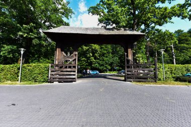 Maramures Gate, meşe ağacından yapılmış, genellikle farklı çiçek motifleriyle oyulmuş en az üç sütun, üst kapı eşiği kiremitlerle kaplı.