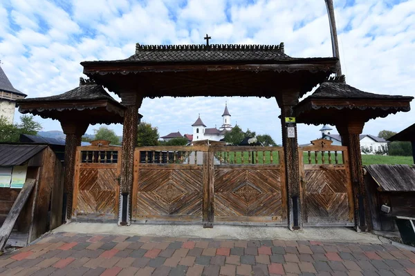 一般的に異なる伝統的な花のモチーフで彫刻された少なくとも3本の柱の上にオークの木で作られたMaramures Gateは 門の上部のしきい値が帯状に覆われています — ストック写真