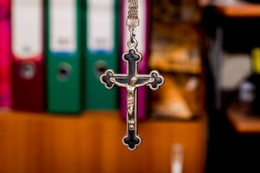 Karanlık bir arka planda metal haç. Din kavramı. Hristiyan sembolleri. Ortasında İsa figürü olan erkek haçı, gümüşten yapılmış, kordonla takılmış. Zincirle de takılabilir.