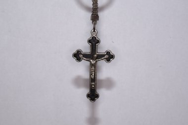 Karanlık bir arka planda metal haç. Din kavramı. Hristiyan sembolleri. Ortasında İsa figürü olan erkek haçı, gümüşten yapılmış, kordonla takılmış. Zincirle de takılabilir.